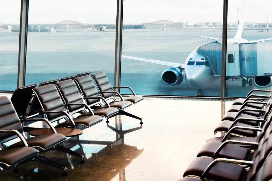 Väntsal på flygplats med utsikt mot ett flygplan vid gaten